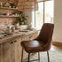 Dining area with wooden table and chairs in a rustic kitchen setting.