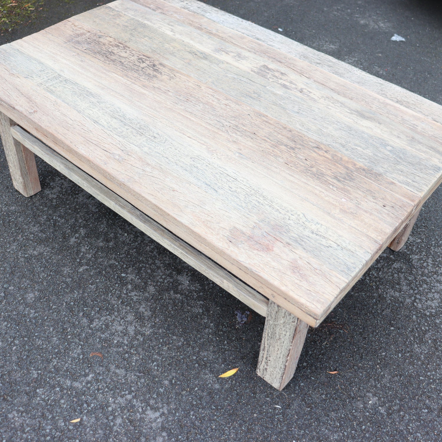 Wooden table on a dark asphalt surface