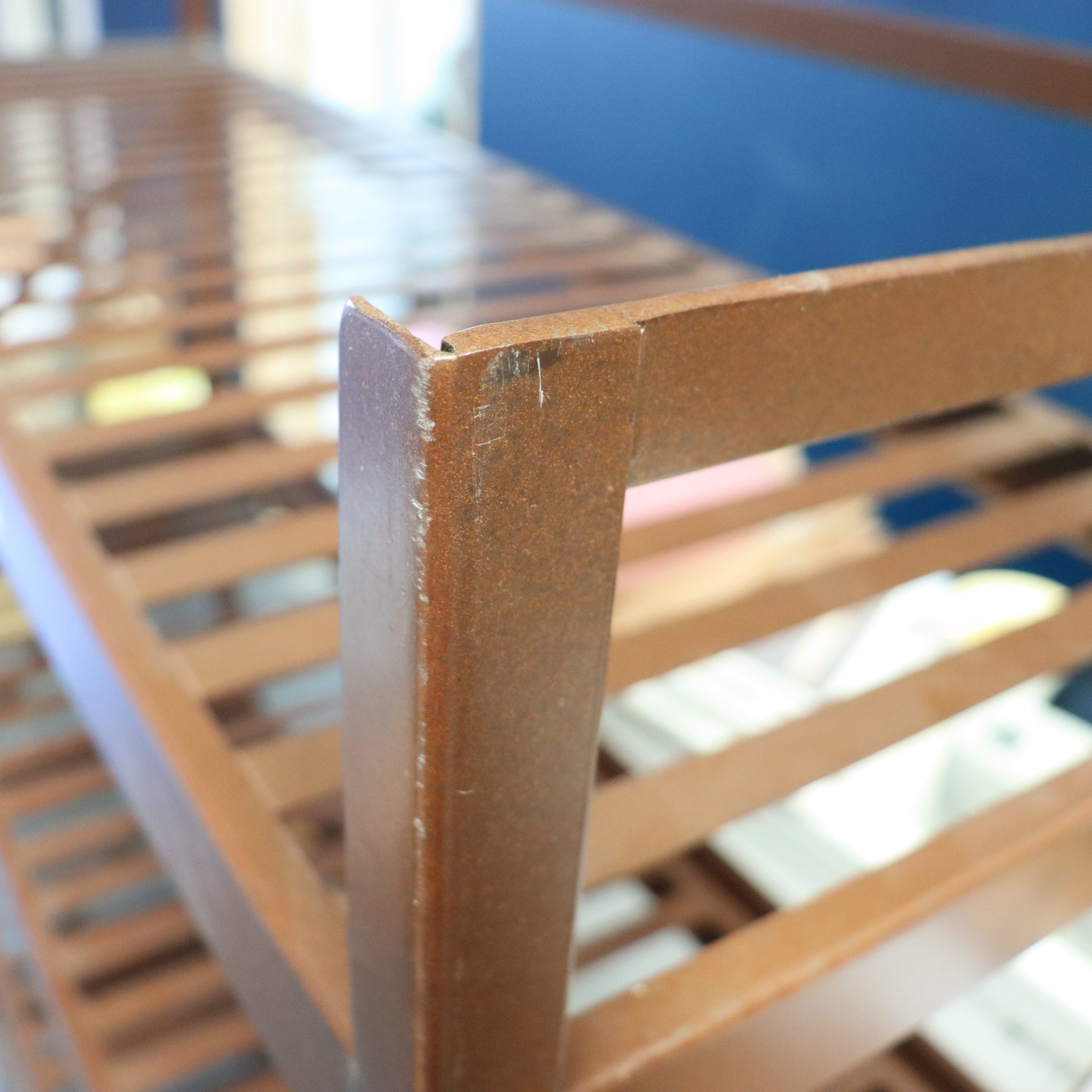 Close-up of a wooden chair with slatted backrest, blurred background