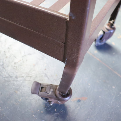 Close-up of a metal cart with wheels on a concrete floor