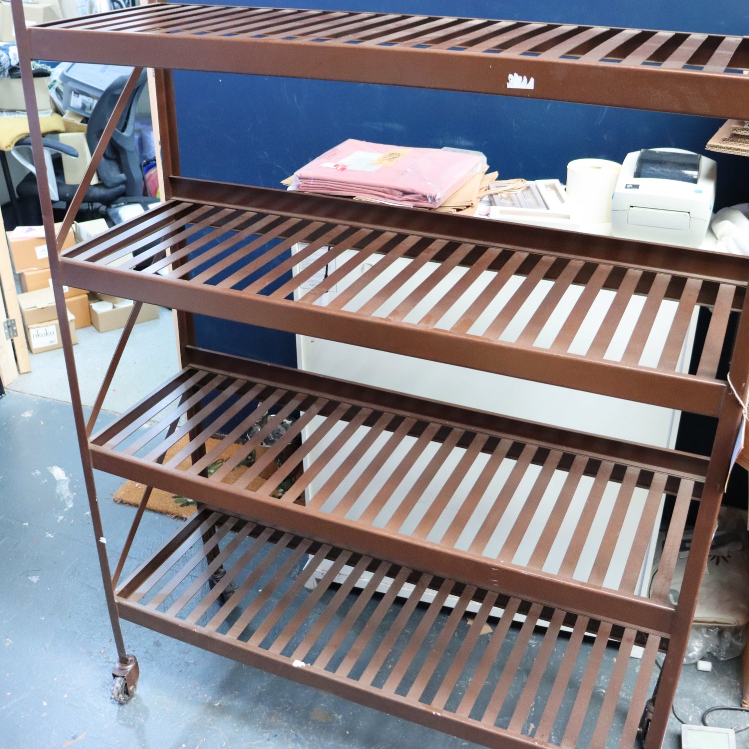 Brown metal shelving unit with multiple shelves in a warehouse setting.