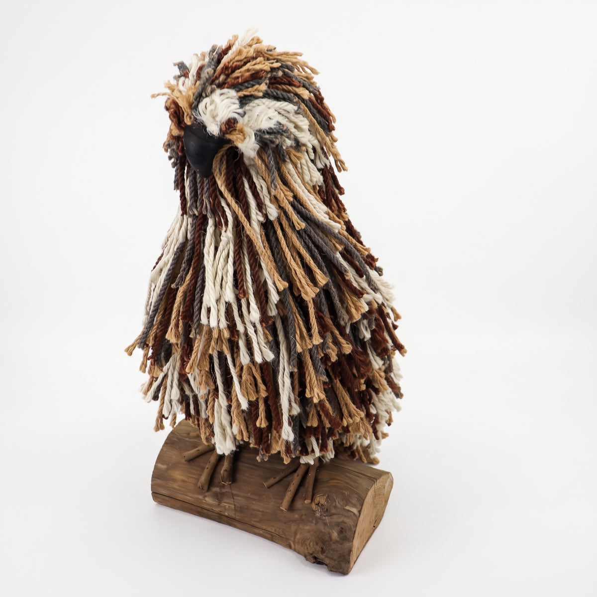 A handmade bird sculpture or figurine with textured, frayed feathers in brown, beige, and off-white, mounted on a rustic dark wood base against a plain white background.