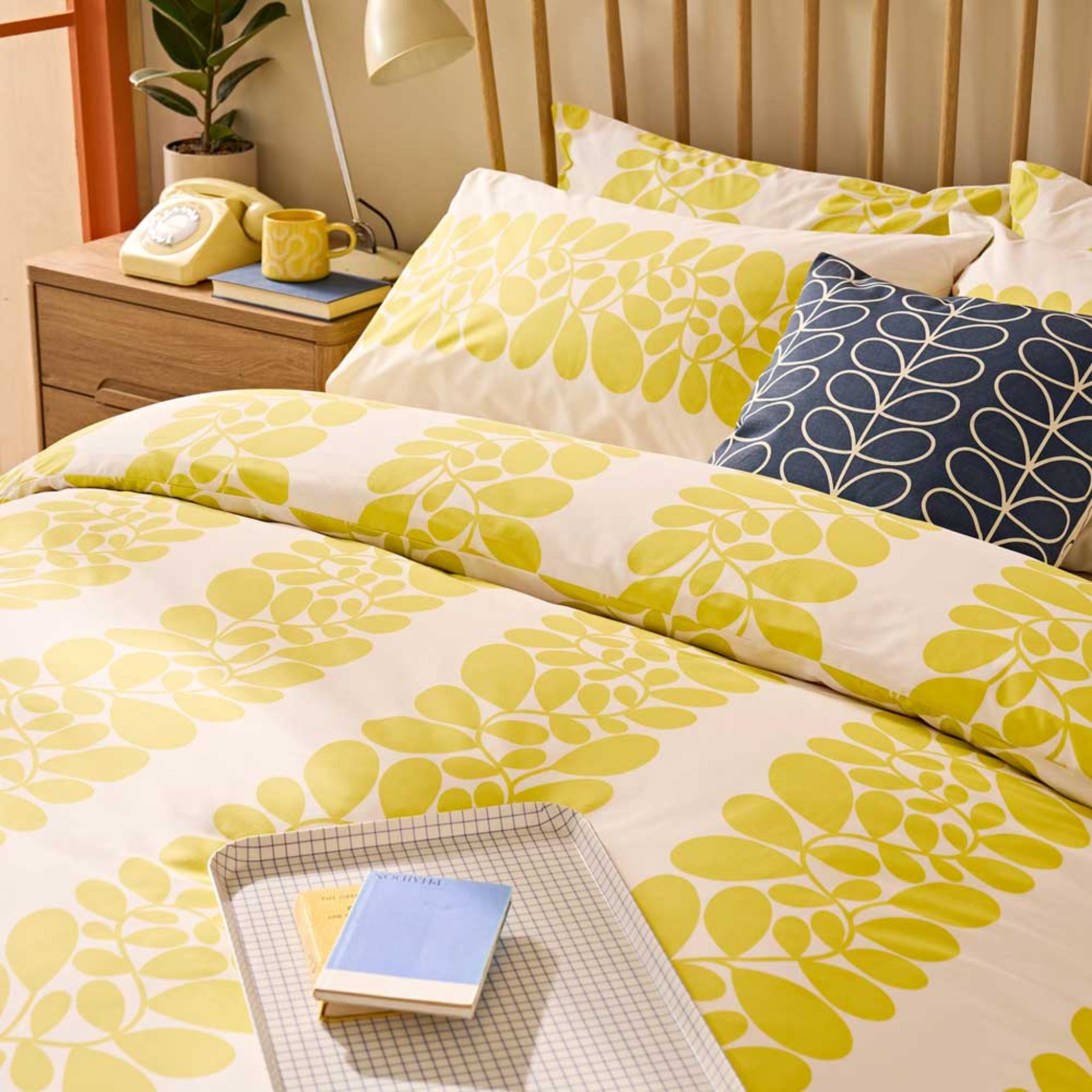 Floral patterned bedding set on a bed with a nightstand in the background.