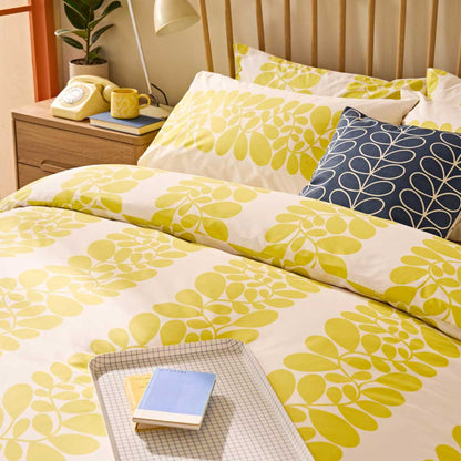 Floral patterned bedding set on a bed with a nightstand in the background.
