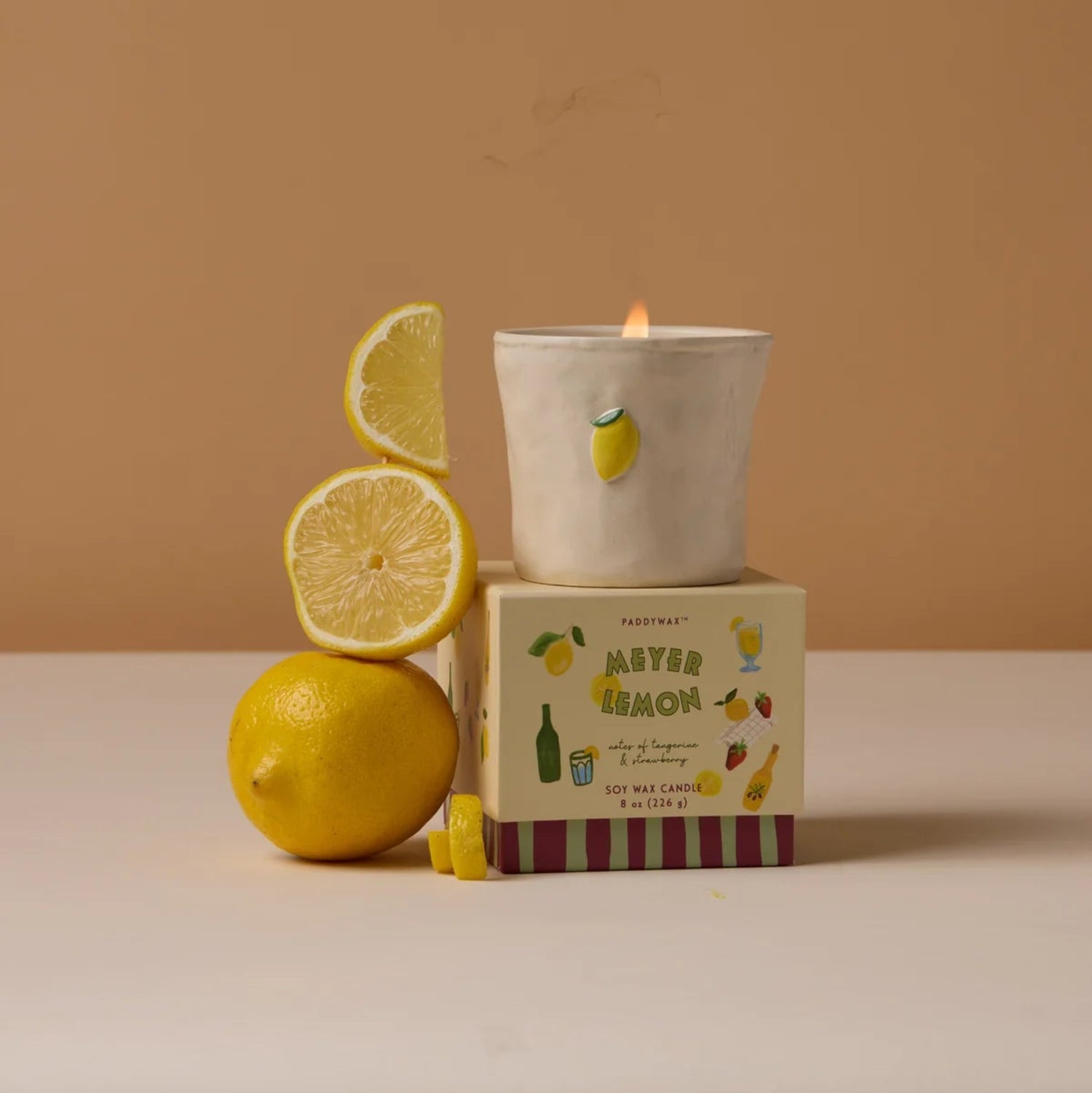 Candle with lemon design on a brown background