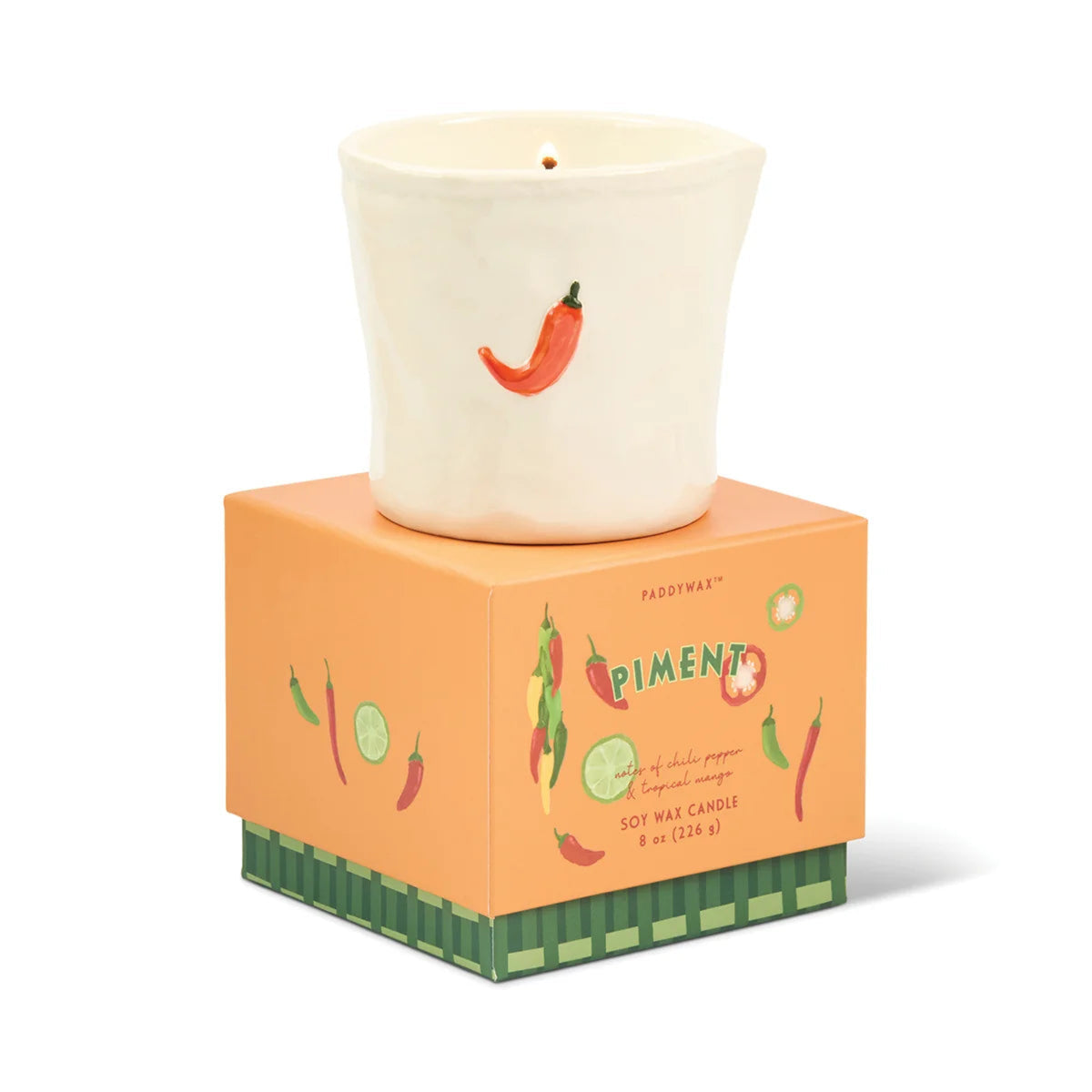 Candle with chili pepper design on a matching box against a white background