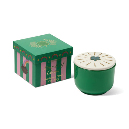 Green candle with white lid and decorative box on a white background