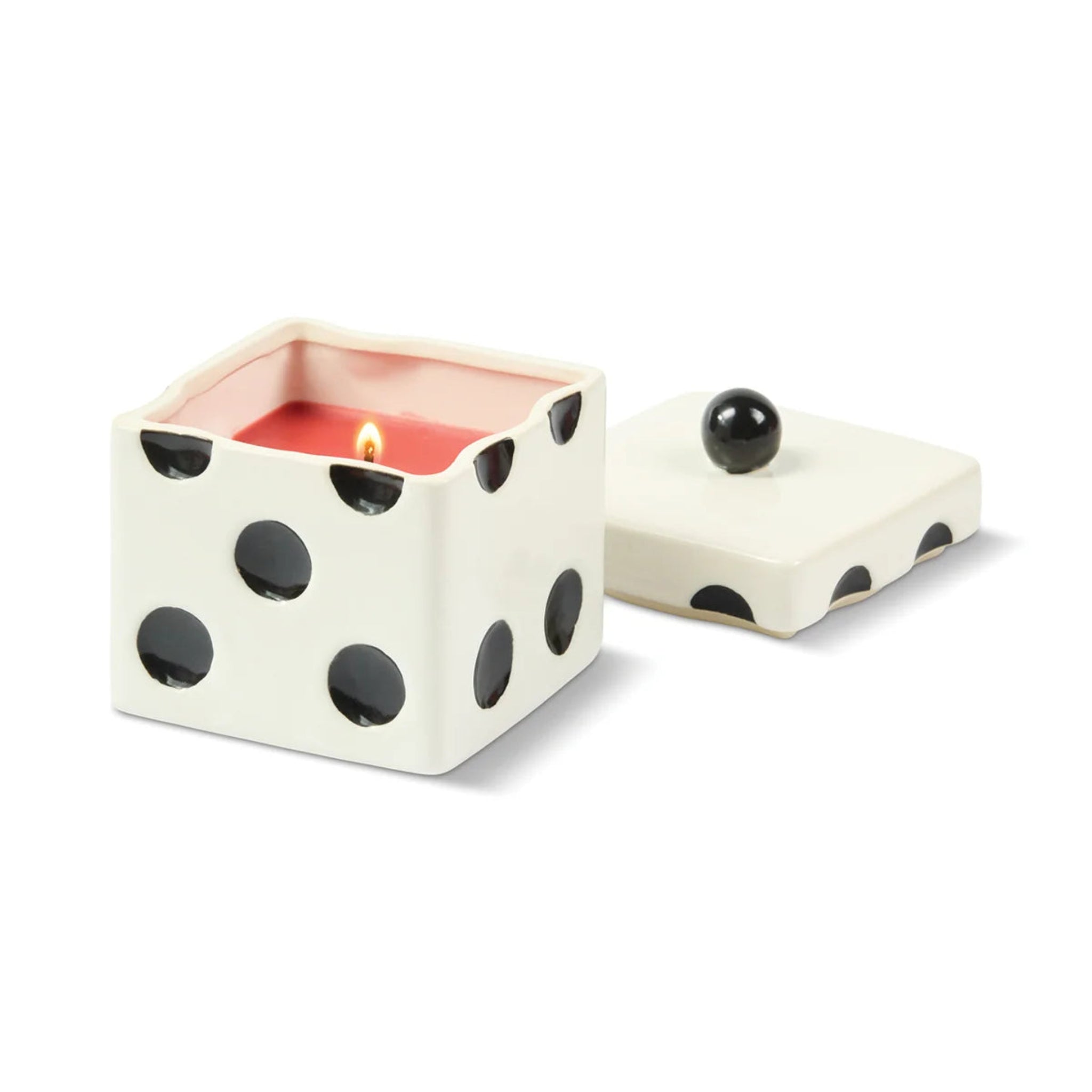 Ceramic dice-shaped candle with a lit wick on a white background