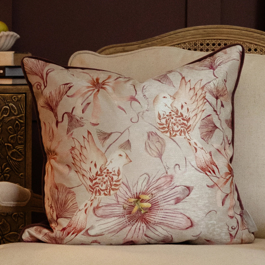 Floral-patterned pillow on a beige sofa with a decorative side table in the background.