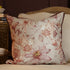 Floral-patterned pillow on a beige sofa with a decorative side table in the background.