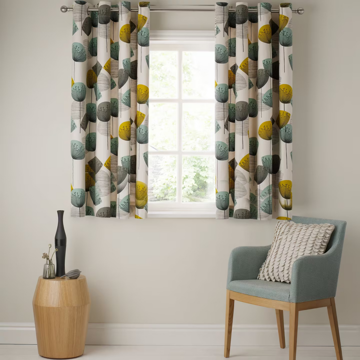 Patterned curtains in a room with a chair and small table.