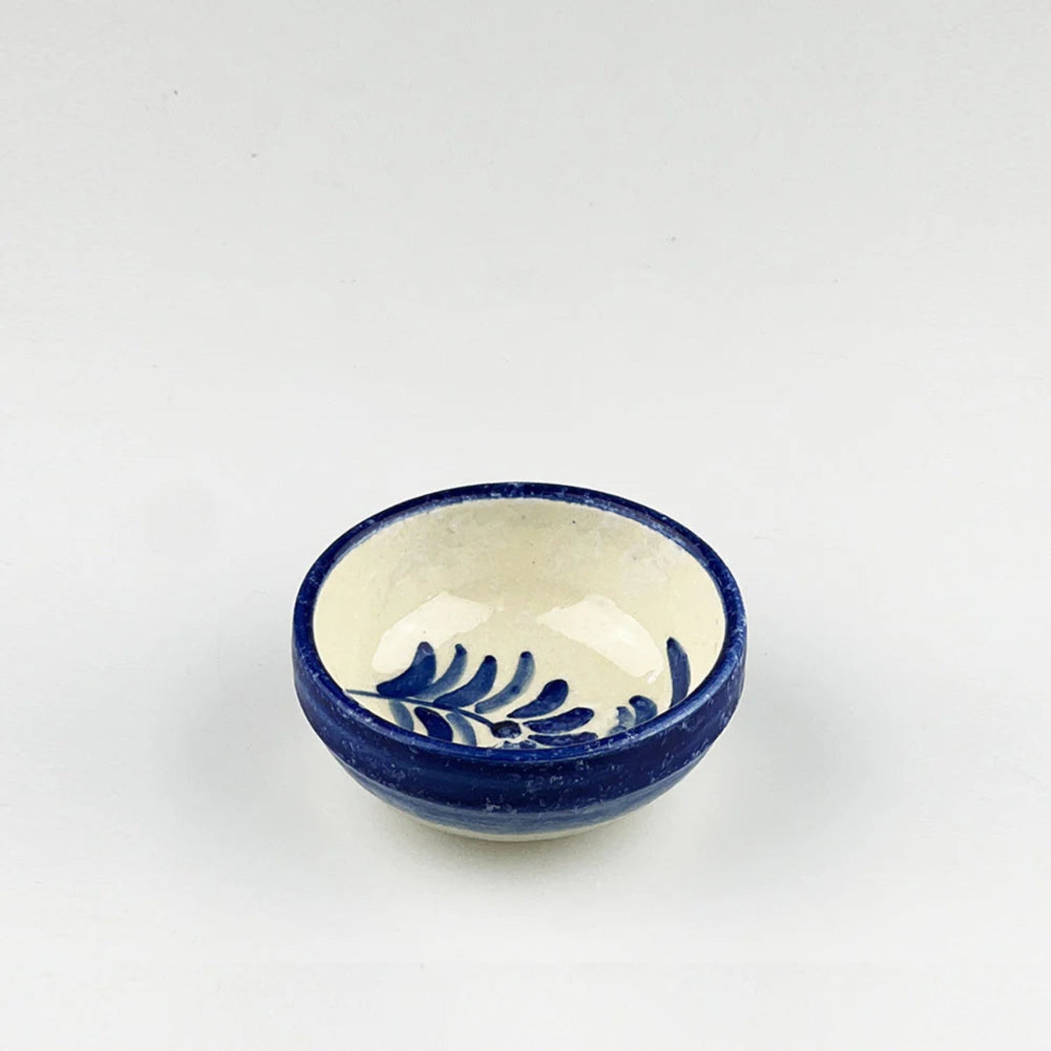 Ceramic bowl with blue exterior and white interior on a light gray background