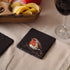 Slate coaster with Robin design on a table with chips and wine