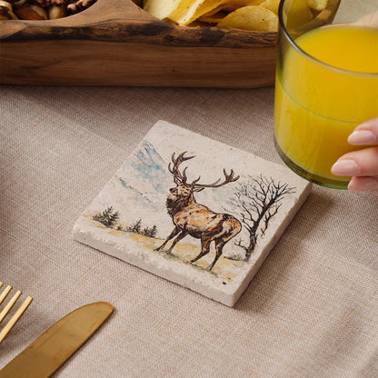 Coaster with deer design on a table with a glass of orange juice.