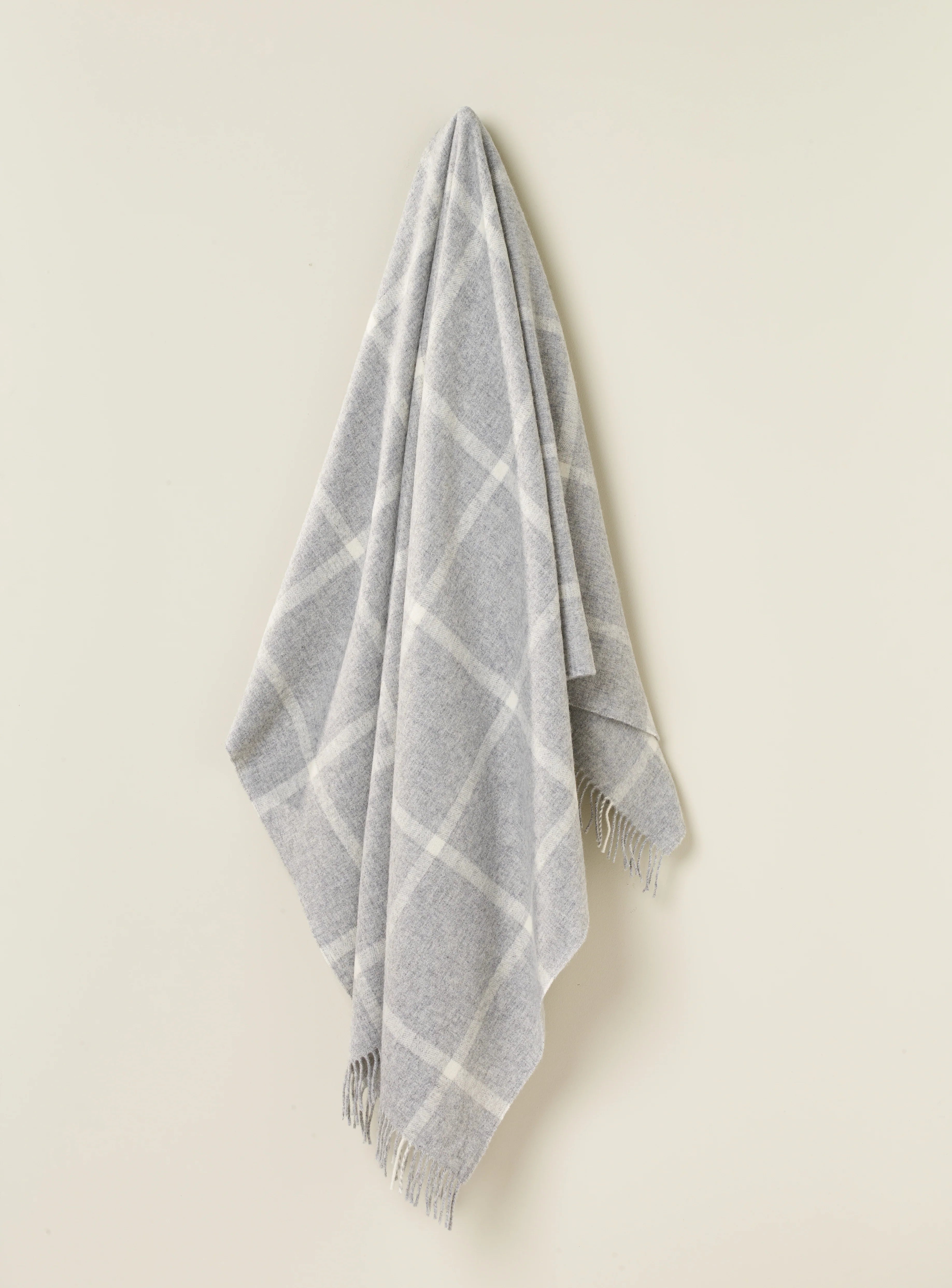 a grey and white plaid blanket on a hook
