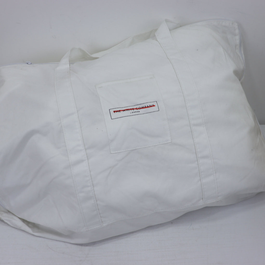 White tote bag with a logo on a white background