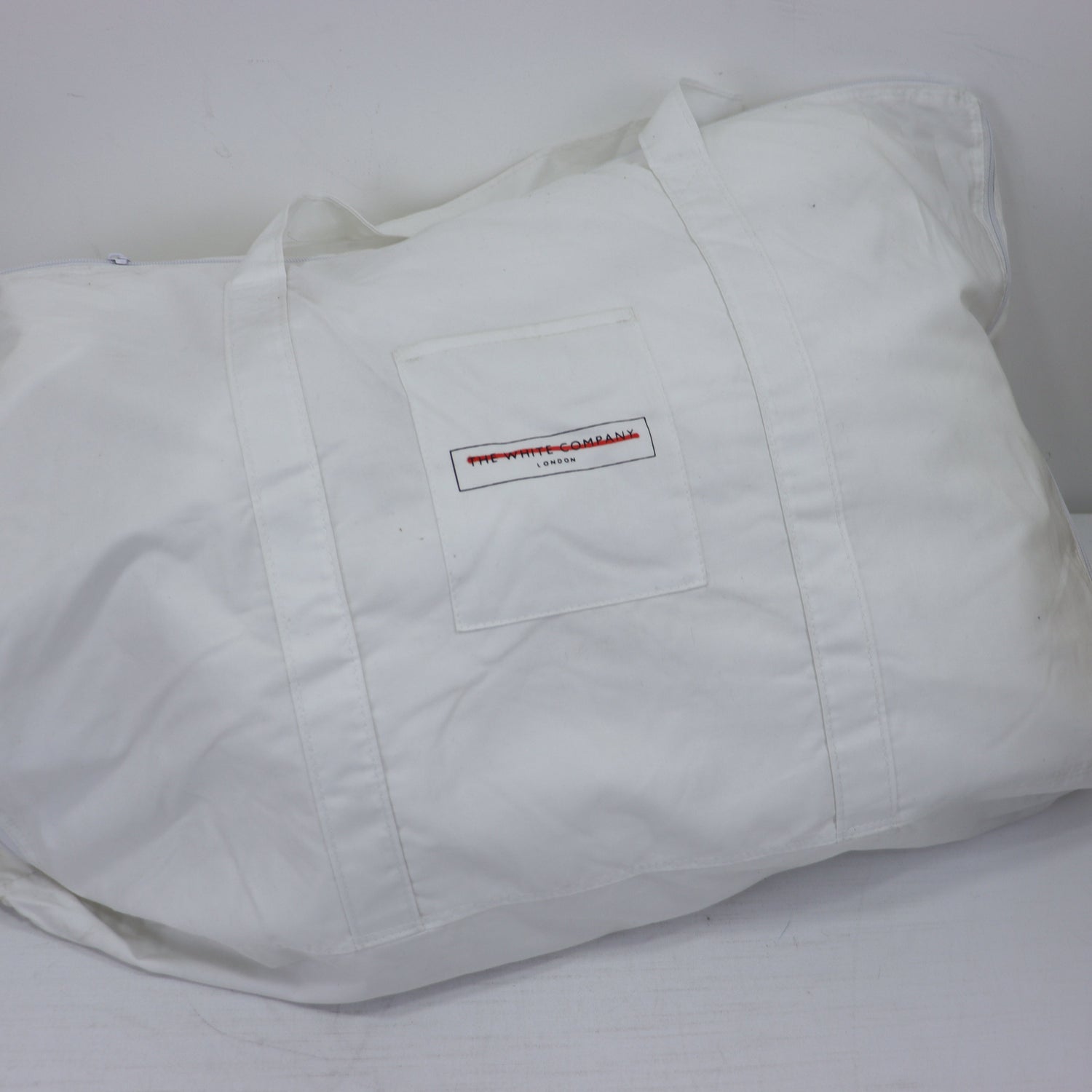 White tote bag with a logo on a white background
