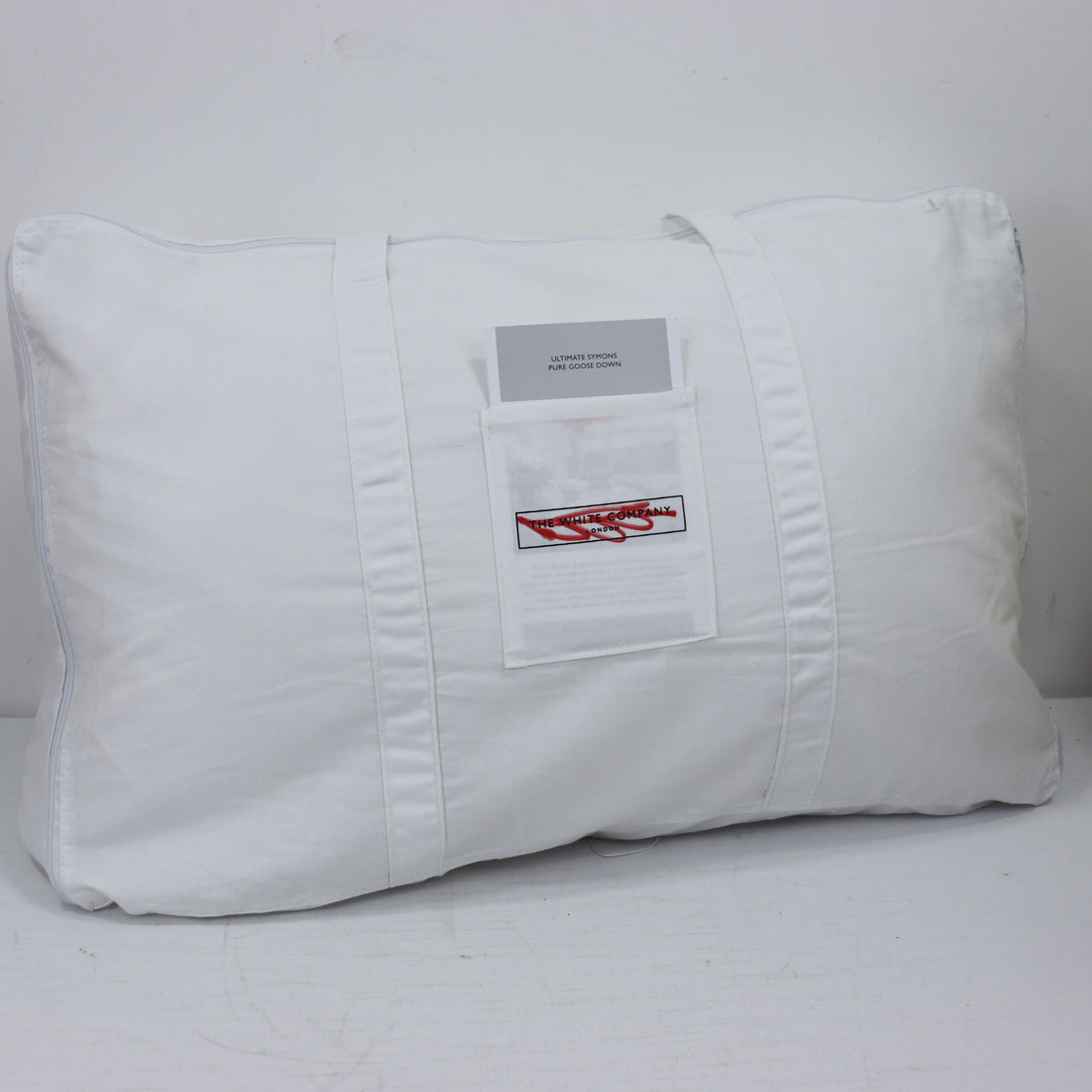 White pillow with a label on a white background