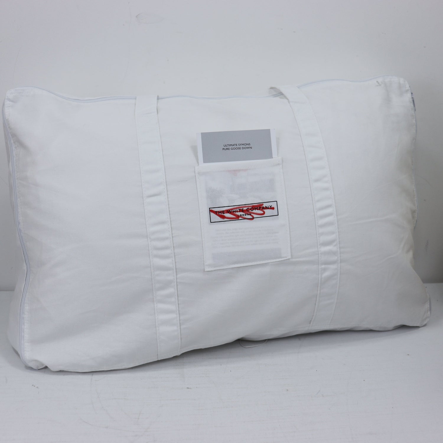 White pillow with a label on a white background