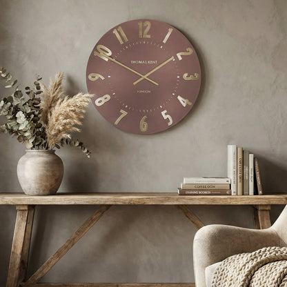 Living room with a clock on the wall, table with decor items, and armchair.