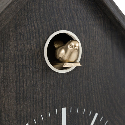 Cuckoo clock with a gold-colored bird peering out from a hole in the wooden casing.