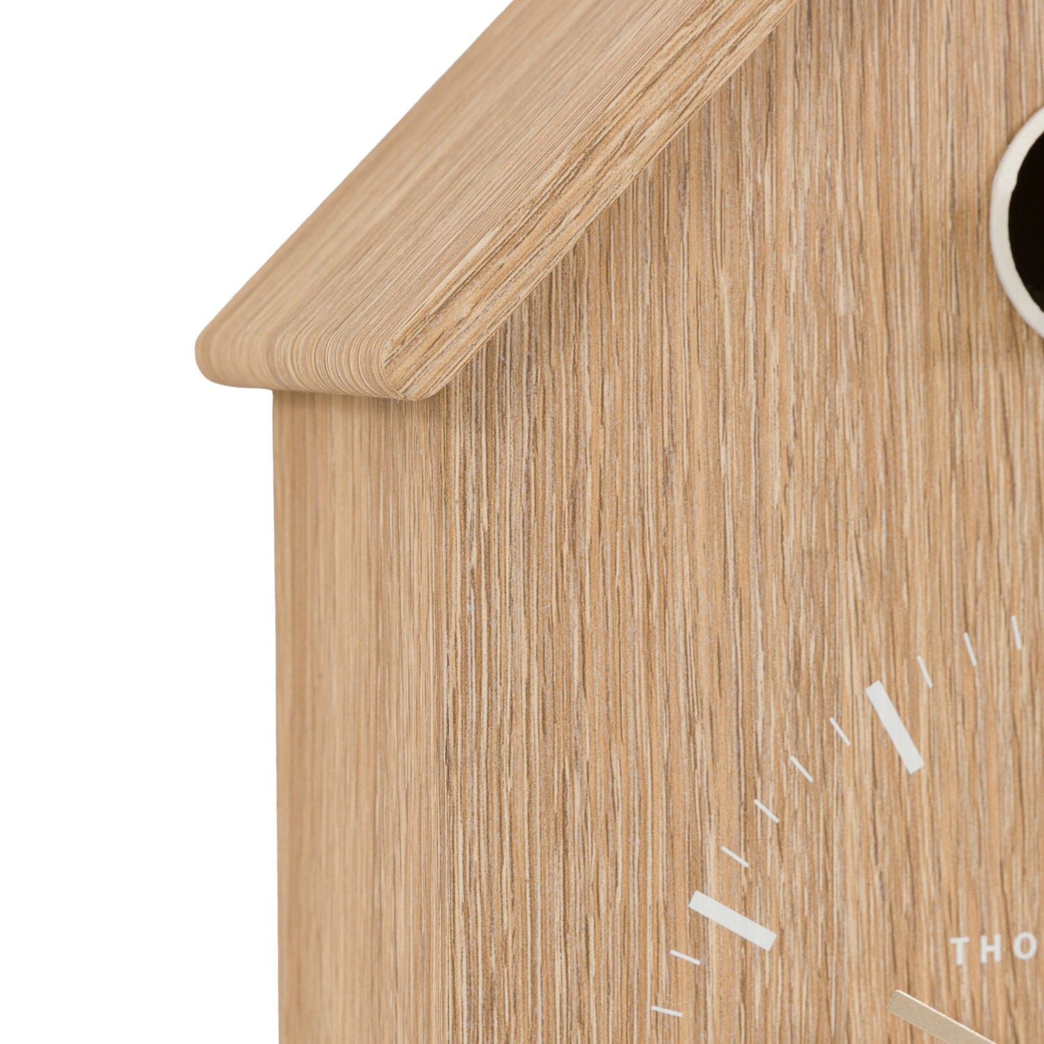 Wooden cuckoo clock with a white face on a white background