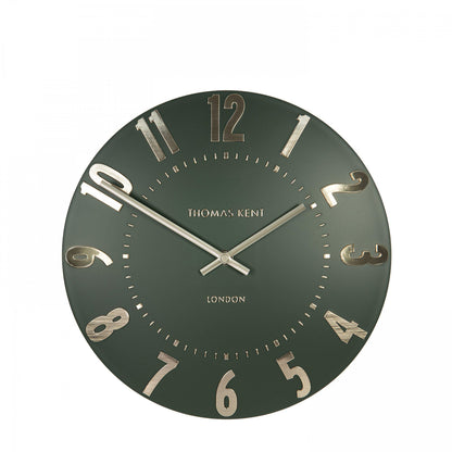 Green wall clock with gold accents on a white background