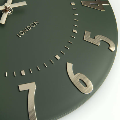 Green clock face with metallic numbers and &