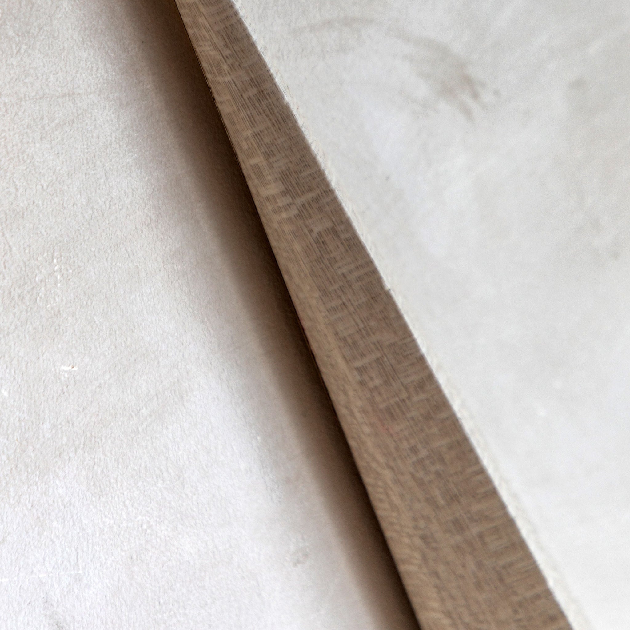 Close-up of a wooden strip on a textured white surface
