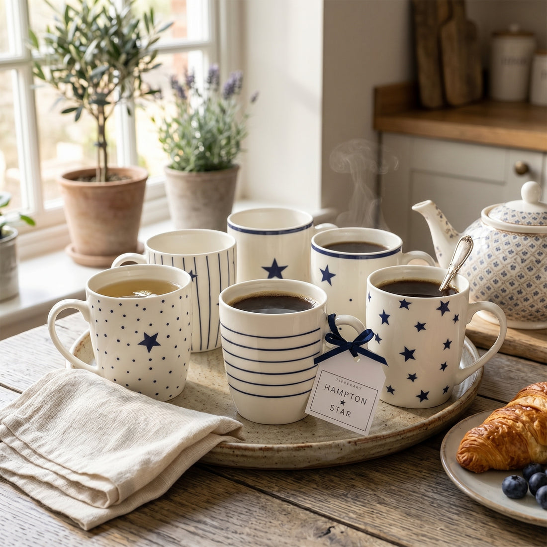 Set of coffee mugs with star patterns on a tray in a kitchen setting.