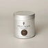 A silver metal tin candle from the brand True Grace, labeled &