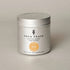 True Grace scented candle in a silver tin on a beige background