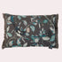 A square decorative throw pillow with dark gray fringed edges, featuring a printed design of magpie birds, leaves, and pocket watches on a dark gray background. A small fabric tag on the right edge reads &