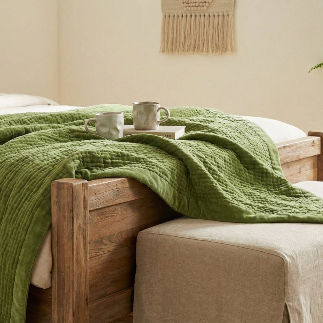 Bedroom with a wooden bed, green blanket, and a small table with a cup.