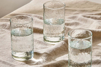 a group of glasses with water on a cloth