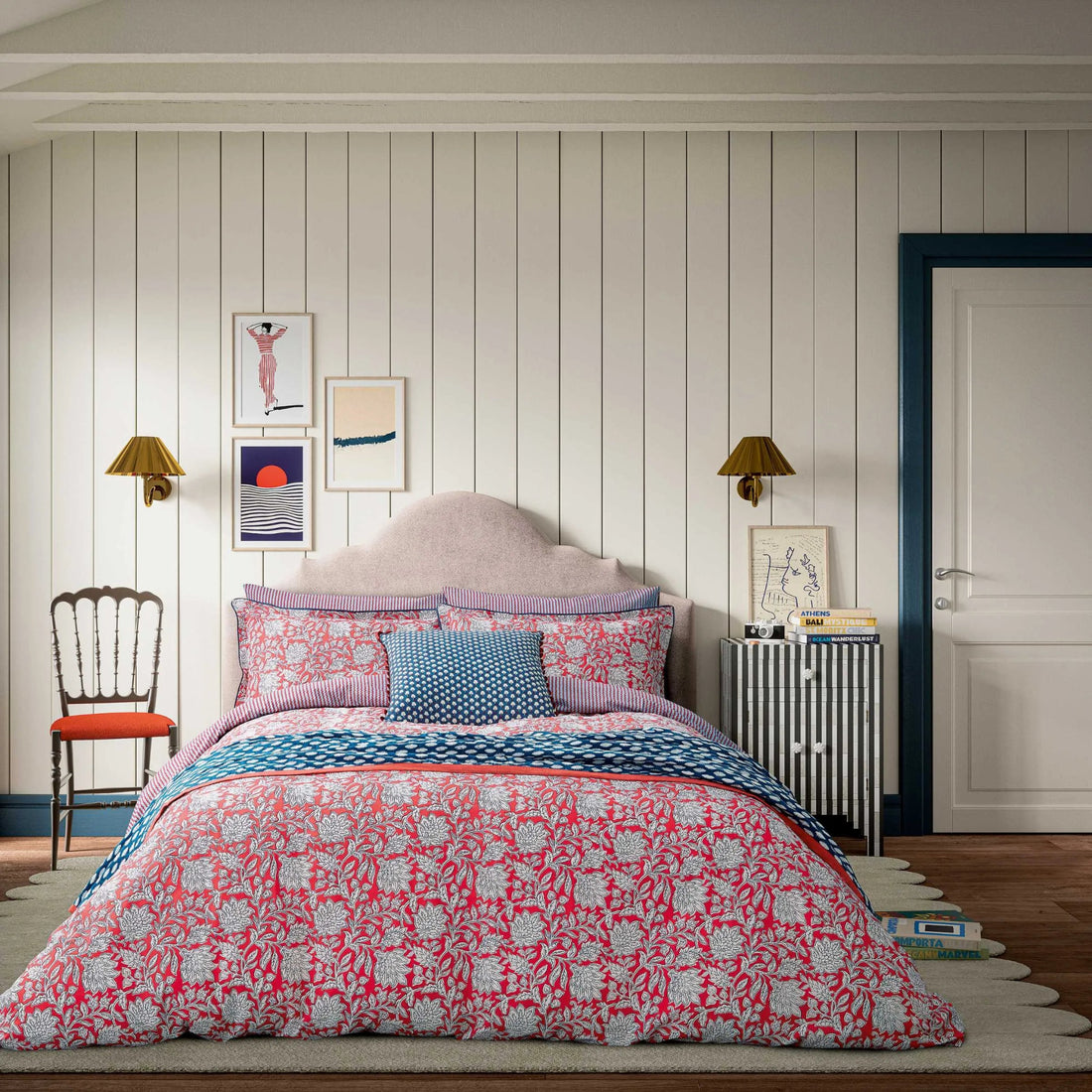 Bedroom with floral bedding and decorative pillows on a bed.