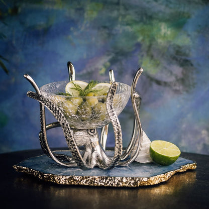 a glass bowl with limes and a slice of lime on a stand
