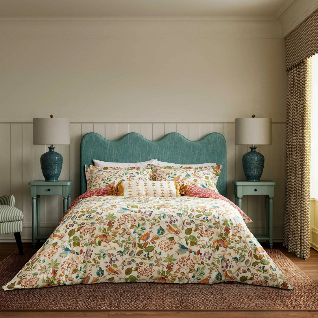 Bedroom with floral bedding, teal headboard, and matching lamps on nightstands.